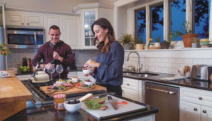 Man and woman in modern kitchen cooking dinner