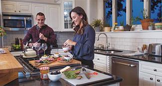 Man and woman in modern kitchen cooking dinner